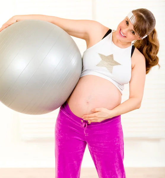 Mujer embarazada haciendo ejercicios de pilates en bola gris — Foto de Stock