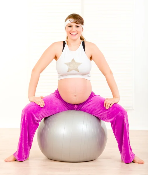 Έγκυος γυναίκα κάνει pilates ασκήσεις σε γκρι μπάλα — Φωτογραφία Αρχείου