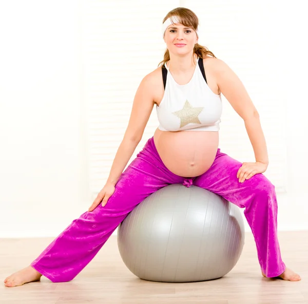 Kobieta w ciąży robi pilates ćwiczenia na szary piłka — Zdjęcie stockowe