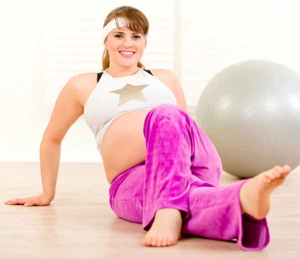Sonriendo hermosa mujer embarazada haciendo gimnasia en casa —  Fotos de Stock