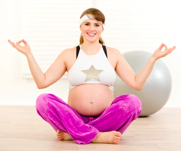 Gülümseyen güzel hamile kadın katta, evde yoga egzersizleri yapıyor — Stok fotoğraf