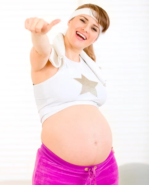 Güzel hamile kadın hareketi yukarı gösteren spor giyim gülümseyen — Stok fotoğraf