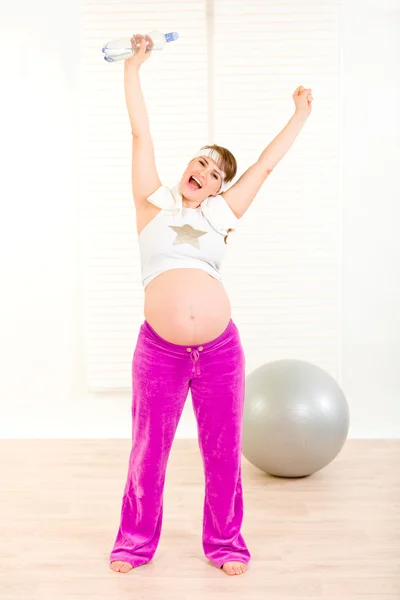 Zadowoleni, piękna kobieta w ciąży w odzieży sportowej, trzymając butelkę wody — Zdjęcie stockowe