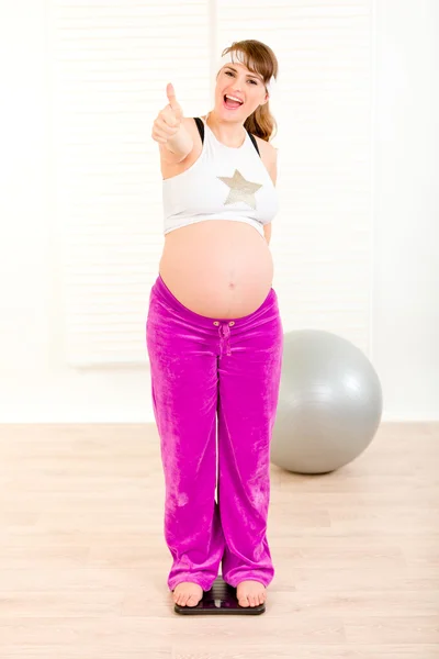 Mujer embarazada de pie en la escala de peso — Foto de Stock
