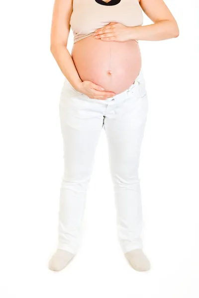 妊娠中の女性は白で隔離される彼女のおなかを保持しています。クローズ アップ. — ストック写真
