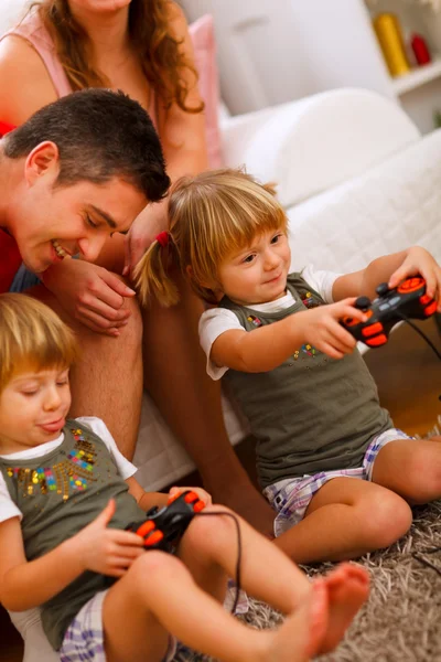 Twins daughters playing on console at home — Stock Photo, Image