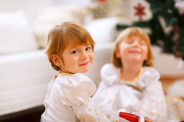 Mutlu kız kardeşiyle Noel ağacının yakınında oynamaktan portresi — Stok fotoğraf