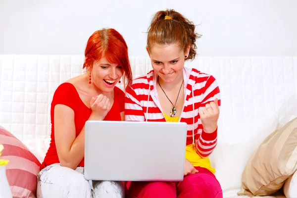 Two happy girlfriends using laptops and showing yes gesture — Stock Photo, Image