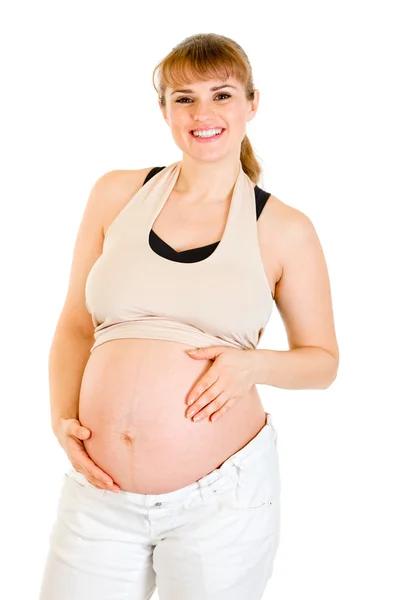 Smiling beautiful pregnant female holding her belly isolated on white Stock Photo