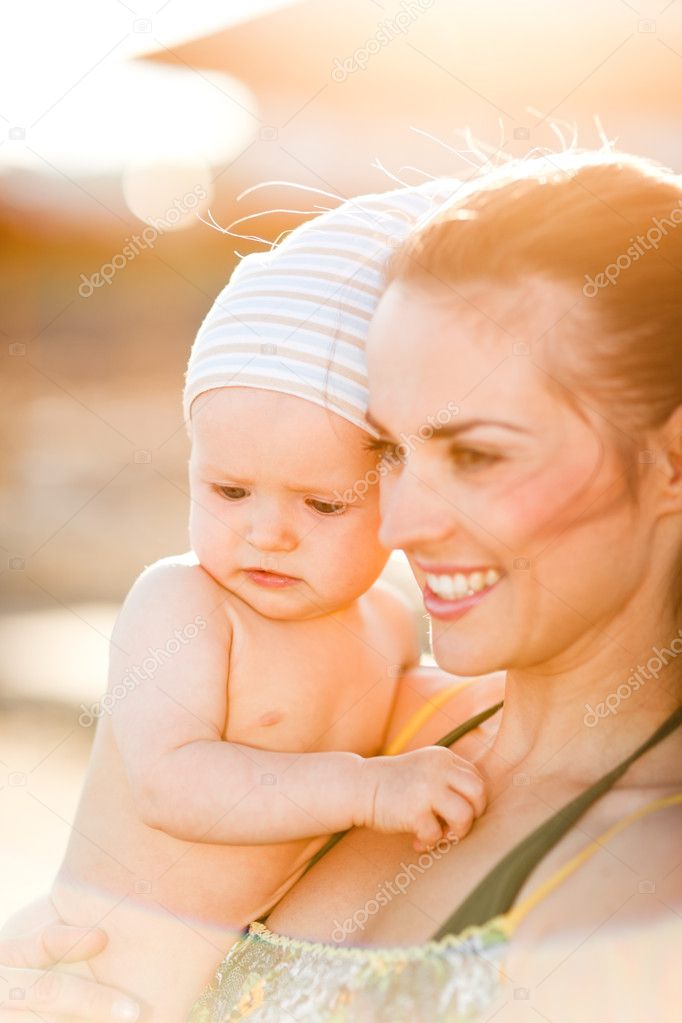 Portrait of young mom with baby on beach