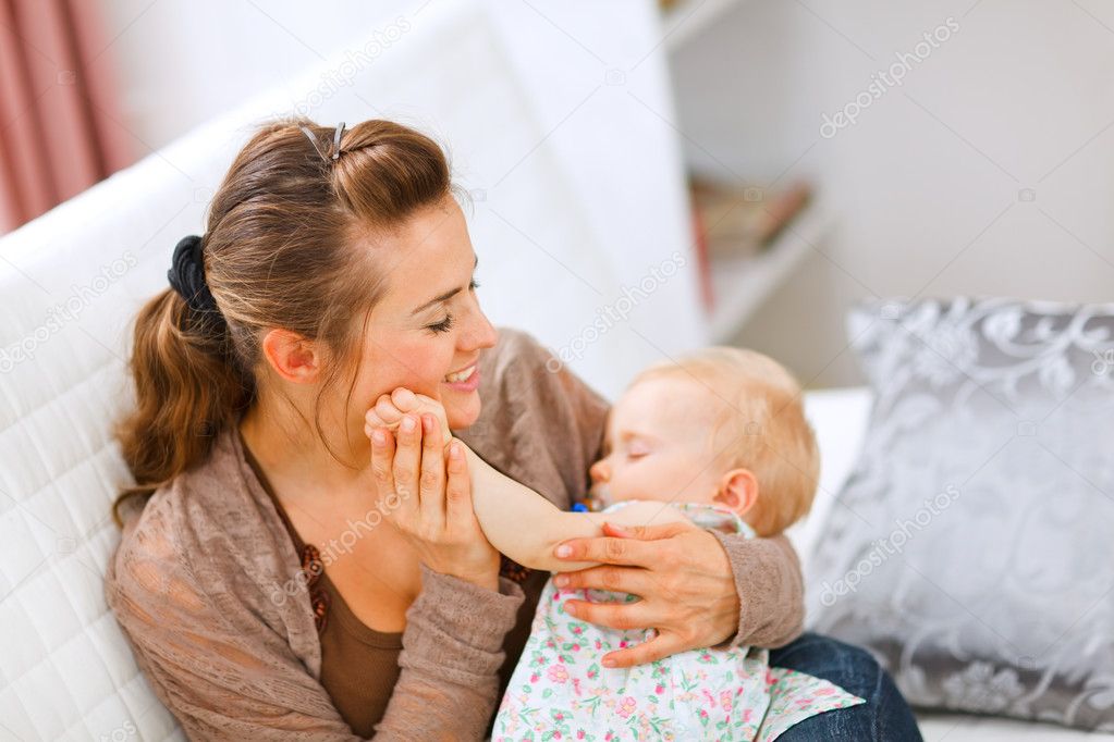 Portrait of young woman enjoying being mothers with baby on hand
