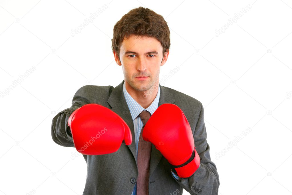 Authoritative modern businessman in boxing gloves punching