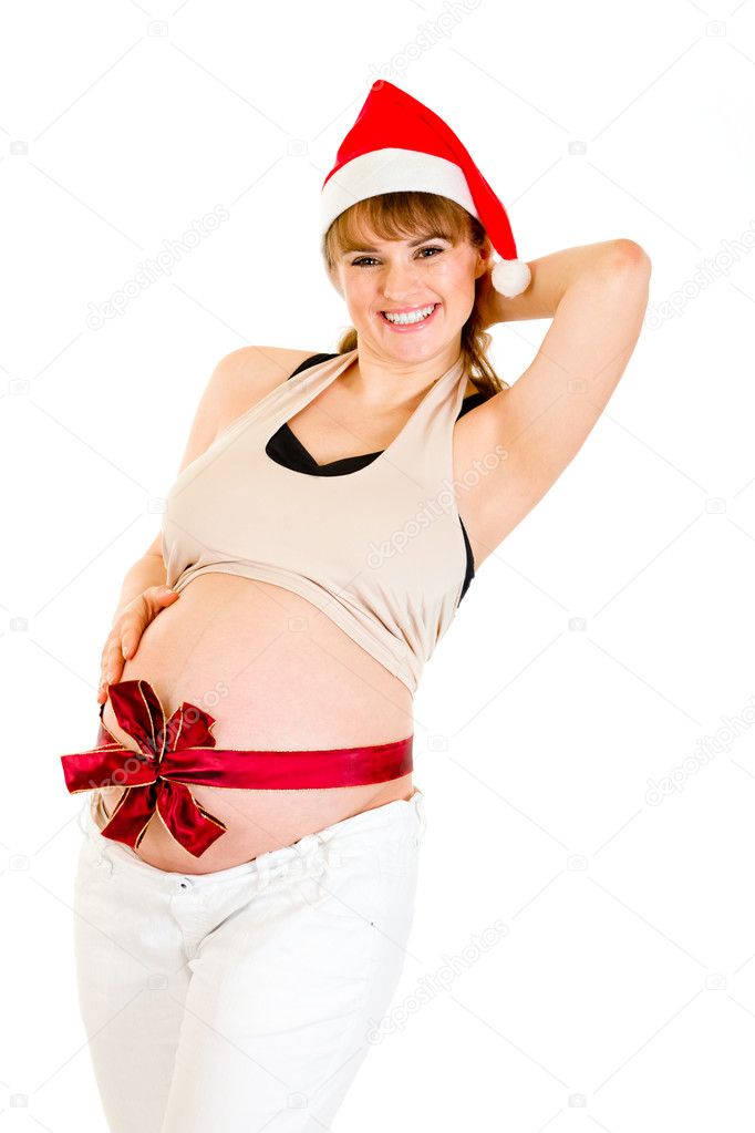 Happy christmas pregnant woman in Santa hat with red ribbon on belly isolated on white