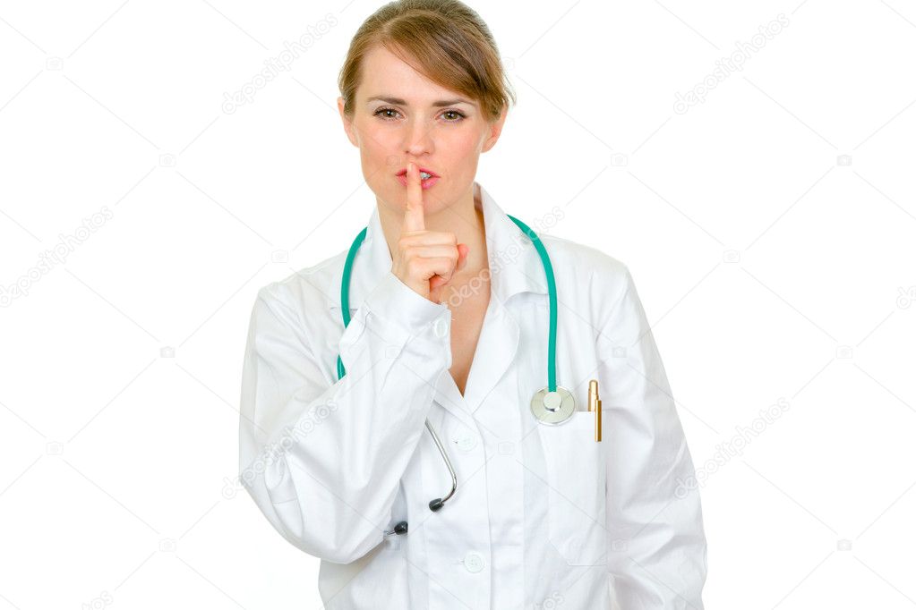 Authoritative medical doctor woman with finger at mouth. Shh gesture