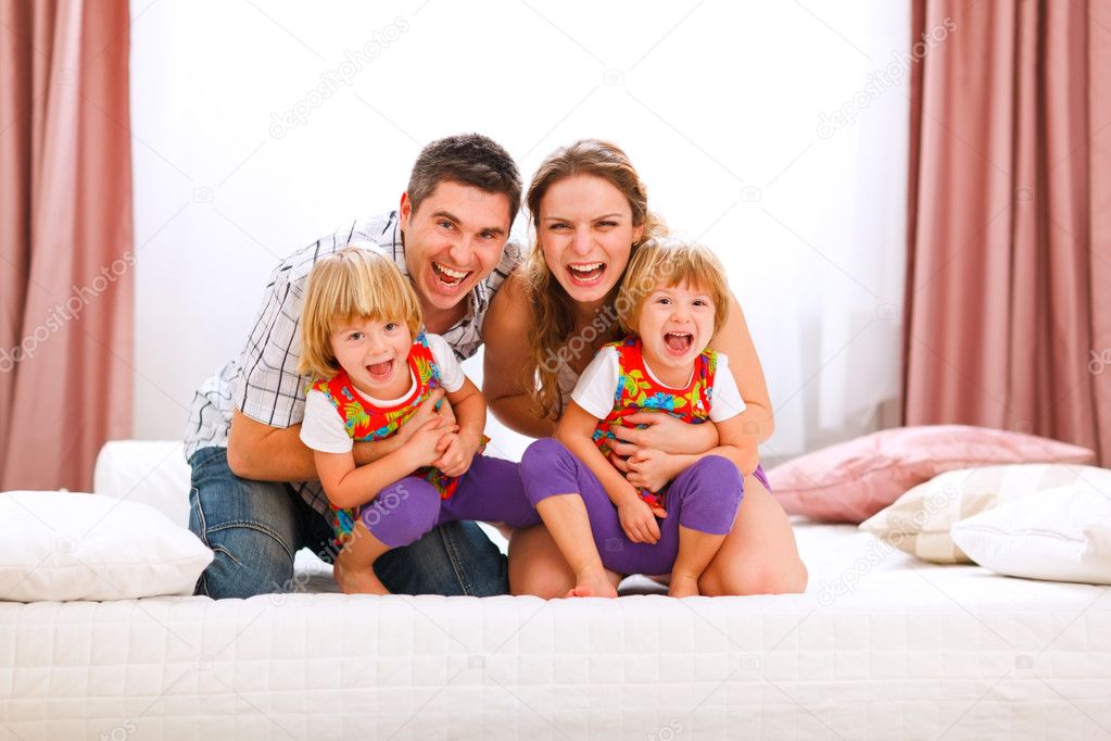 Family portrait of happy mom dad and twins daughters having fun