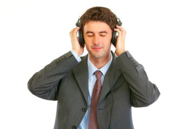 Happy man in business suit listening music in headphones clipart