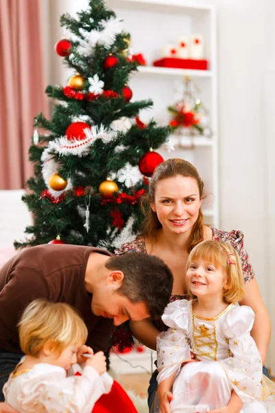 Rodiče s dvěma dcerami trávit čas u vánočního stromu — Stock fotografie