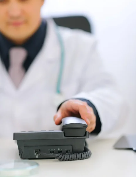 電話の受話器を取る医師の手のクローズ アップ — ストック写真