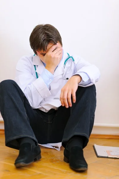 Médico molesto sentado en el suelo —  Fotos de Stock