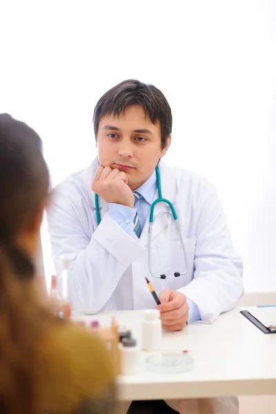 Lekarz siedzi przy stole i słucha uważnie pacjenta — Zdjęcie stockowe