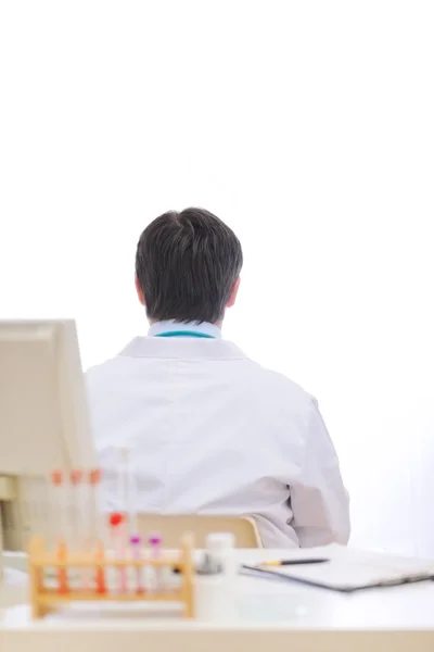 Lékař umístění zády ke stolu v kabinetu — Stock fotografie