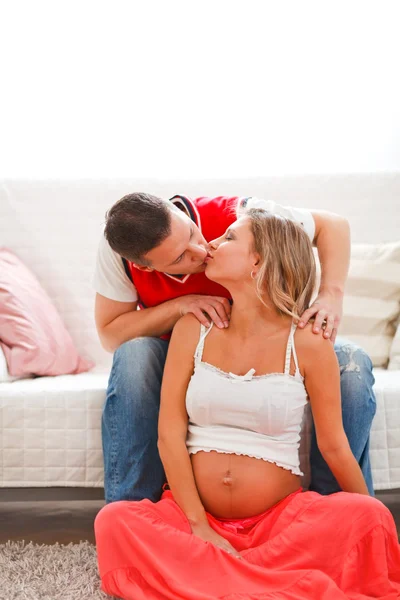 Portret van zwangere vrouw met echtgenoot kussen — Stockfoto