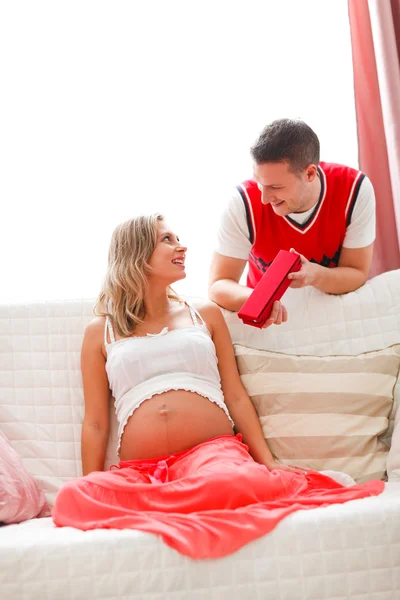 Jeune mari faisant cadeau à la femme enceinte — Photo