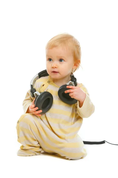 可爱的宝宝用耳机在孤立的 whi copyspace 上看 — 图库照片