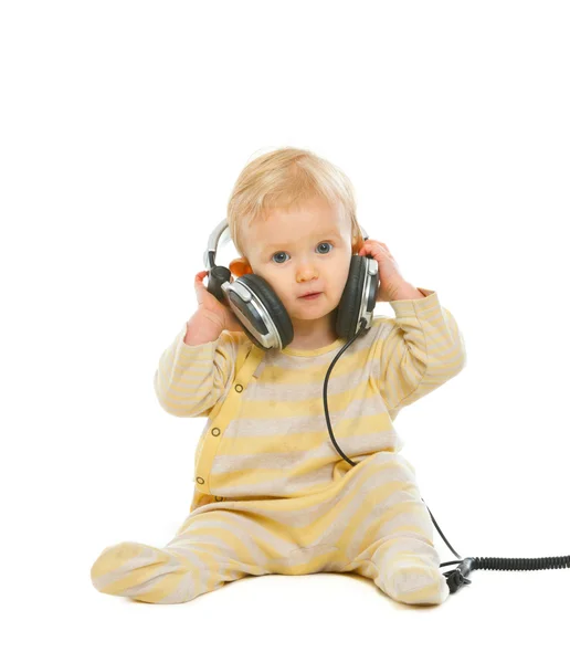 Roztomilé dítě v sluchátka sedět na podlaze izolovaných na bílém — Stock fotografie
