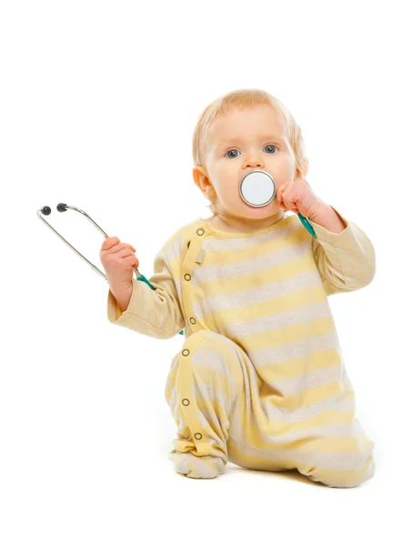 赤ちゃん遊ぶ白で隔離される聴診器 — ストック写真