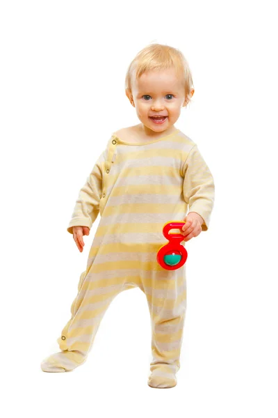 Precioso bebé de pie con sonajero sobre fondo blanco — Foto de Stock