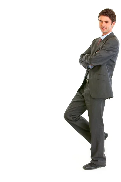 Smiling modern businessman standing back to imaginary wall — Stock Photo, Image