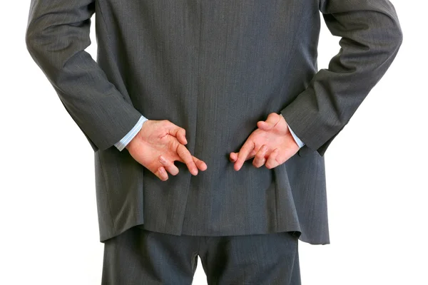 Närbild på händer med korsade fingrar bakom affärsmannen rygg — Stockfoto