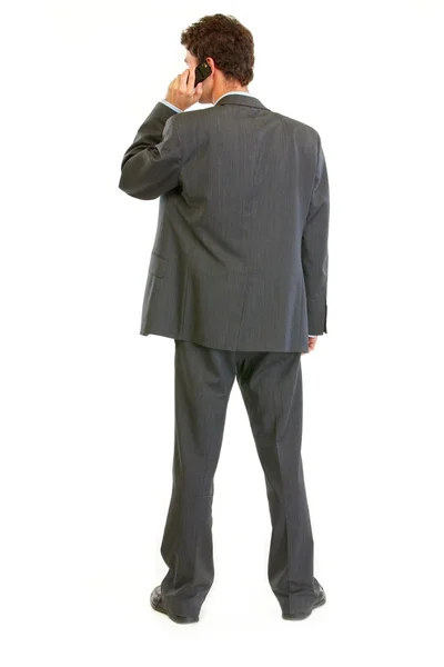 Modern businessman standing back to camera and talking mobile — Stock Photo, Image