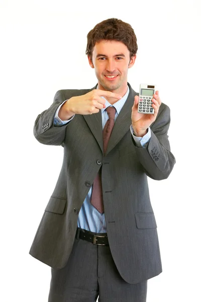 Sorrindo moderno empresário apontando dedo na calculadora — Fotografia de Stock