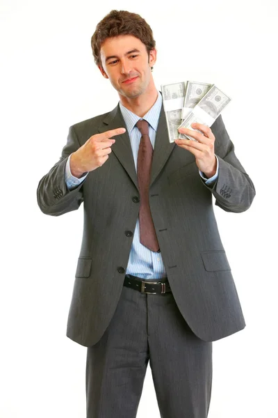 Happy modern businessman pointing on packs of dollars — Stock Photo, Image