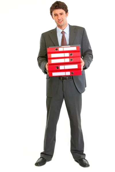 Niezadowolony nowoczesny biznesmen posiadania stos folderów — Zdjęcie stockowe