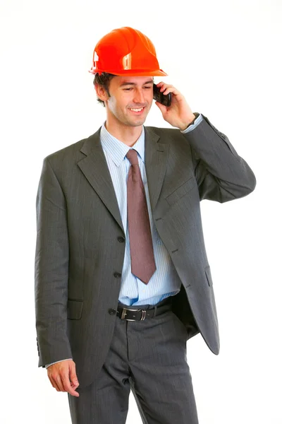 Smiling architect in helmet speaking mobile — Stock Photo, Image