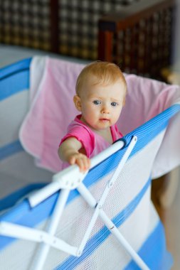 Baby standing in playpen clipart