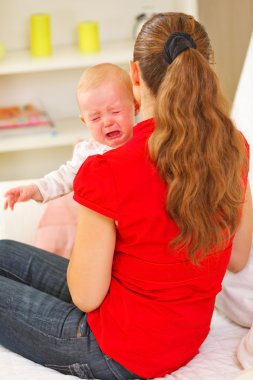 Mother calming crying baby clipart