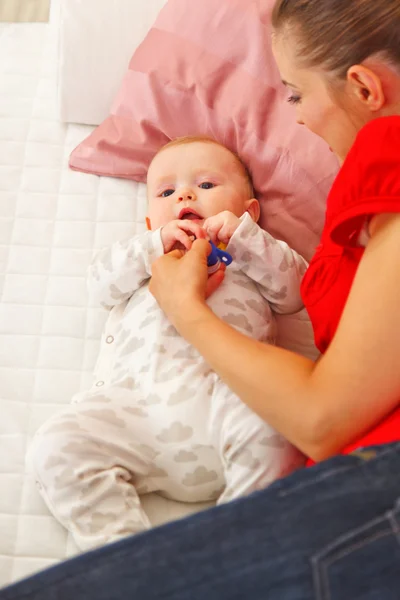 Младенец играет с мамой на диване — стоковое фото