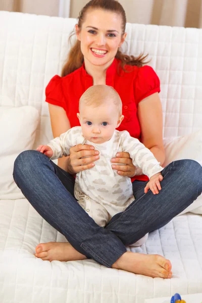 かわいい赤ちゃんの母親の周上に座っています。 — ストック写真