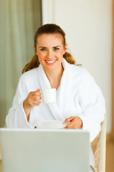 Retrato de mujer sonriente en albornoz con taza de café y regazo —  Fotos de Stock