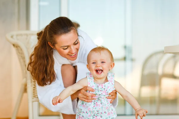 若い母親のテラスで赤ちゃんと一緒に遊んでバスローブ — ストック写真