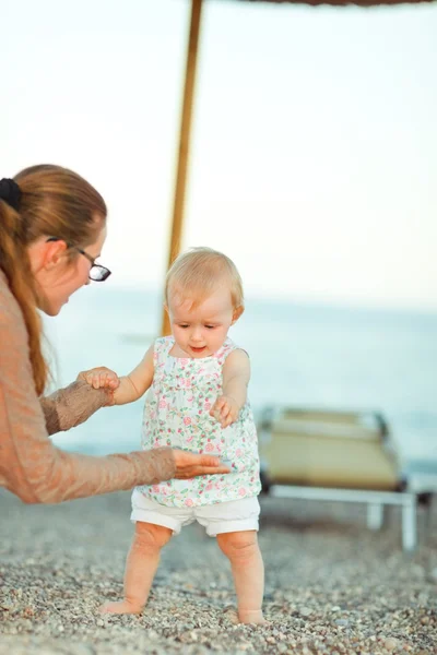 Младенец играет с матерью на пляже — стоковое фото