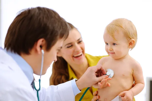 Милый ребенок проходит обследование у врача, используя стетоскоп. — стоковое фото