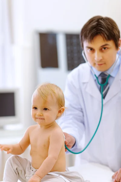 Lindo bebé siendo revisado por un médico usando un estetoscopio —  Fotos de Stock