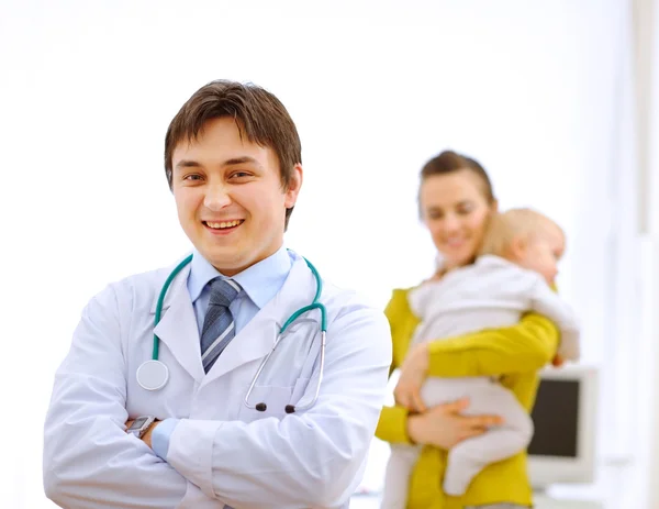 Portrait of pediatrician doctor and mother with baby in backgrou — Stock Photo, Image