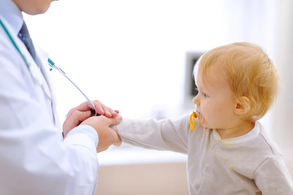 Заинтересованный ребенок растягивается для стетоскопа — стоковое фото