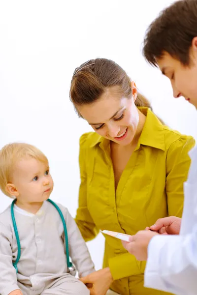 Pediatric doctor förklara något till mamma medan baby SP — Stockfoto
